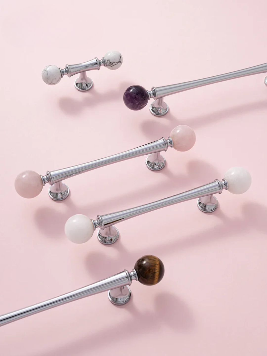 Decorative curtain rods with colorful knobs on a pink background