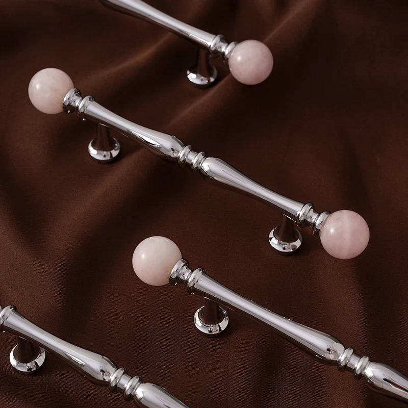 Silver handles with pink spherical ends on a brown fabric background