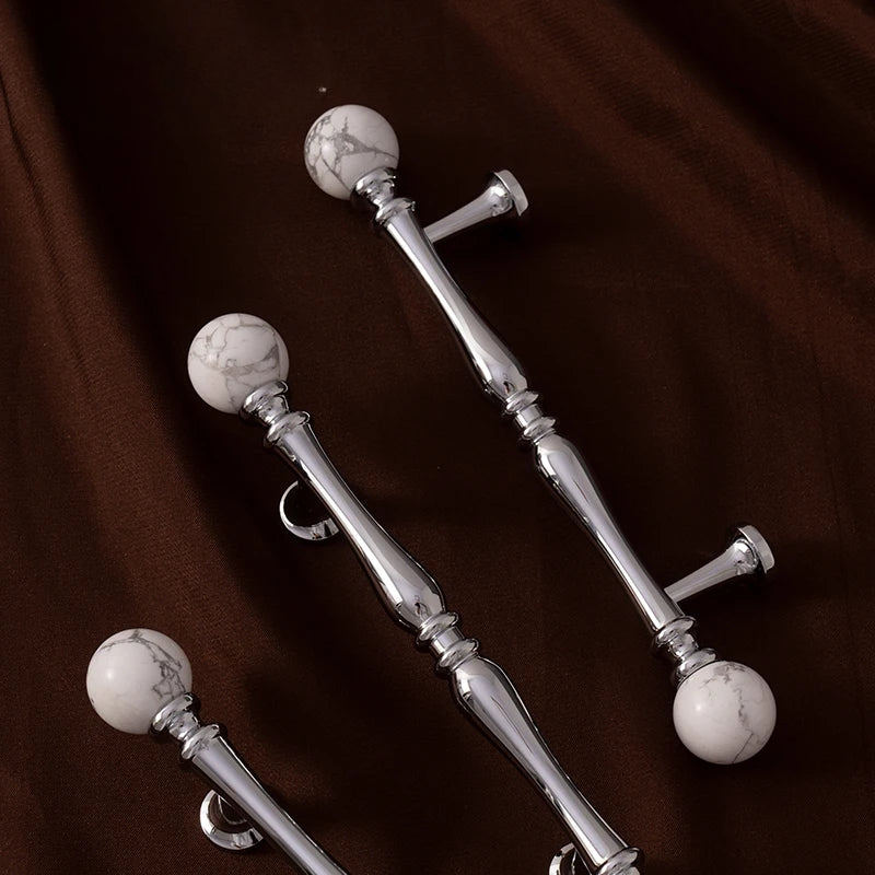 Silver curtain rods with marble ball ends on a brown background