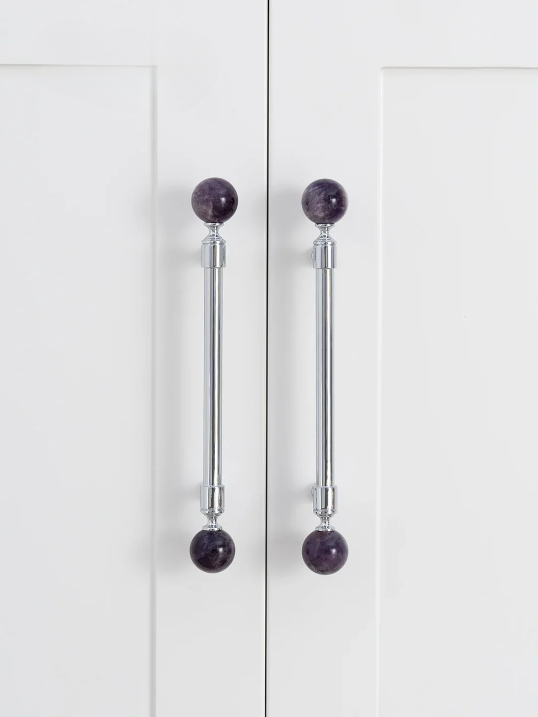 Cabinet doors with purple spherical handles on a white background