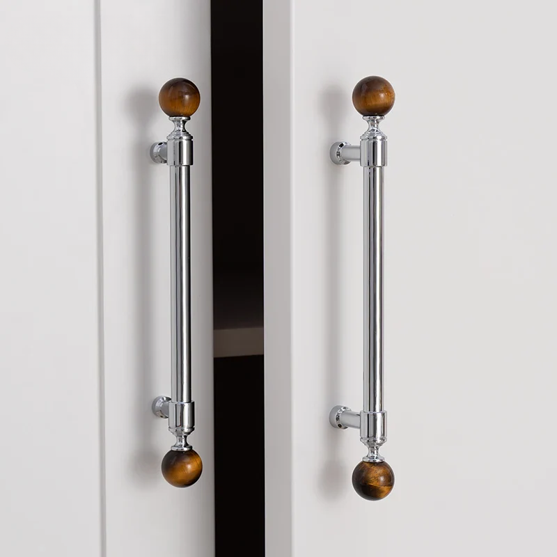 Cabinet handles with brown spherical ends on a white background