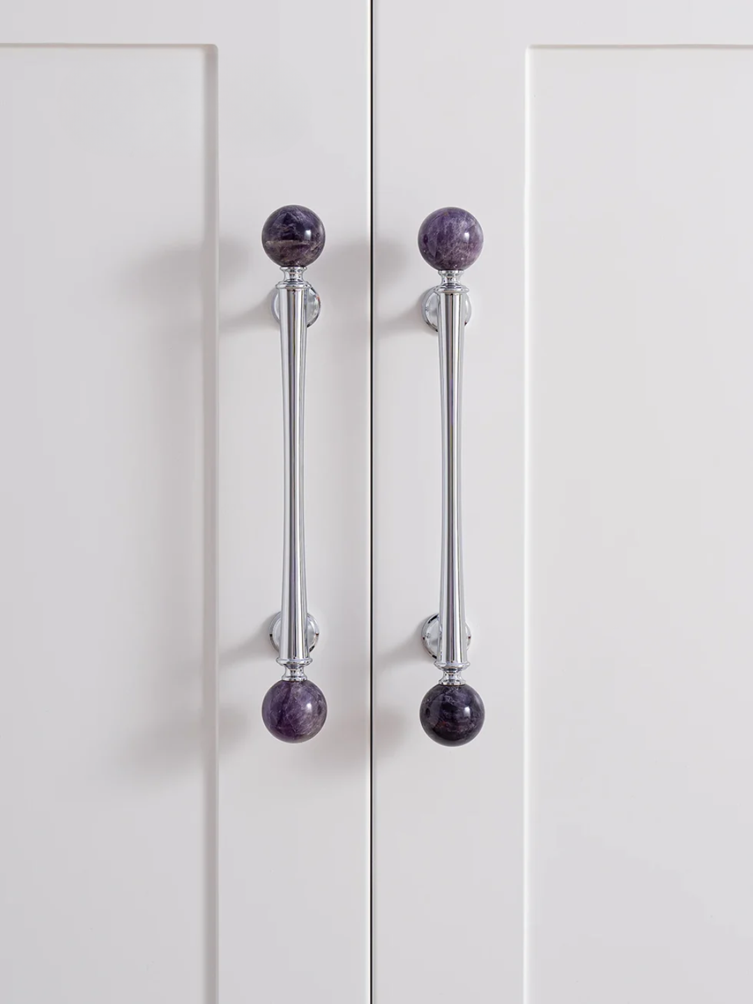 Cabinet doors with purple knob handles on a white background