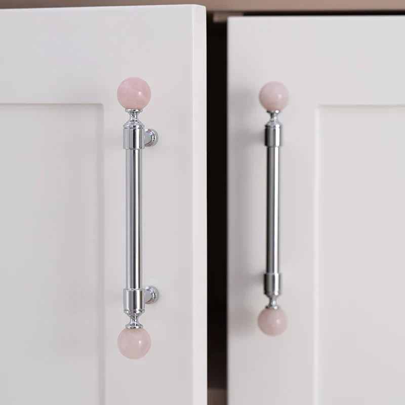 Cabinet doors with pink spherical handles on a white background