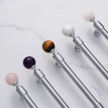 Set of silver telescopic sticks with multicolored spherical ends on a light gray background