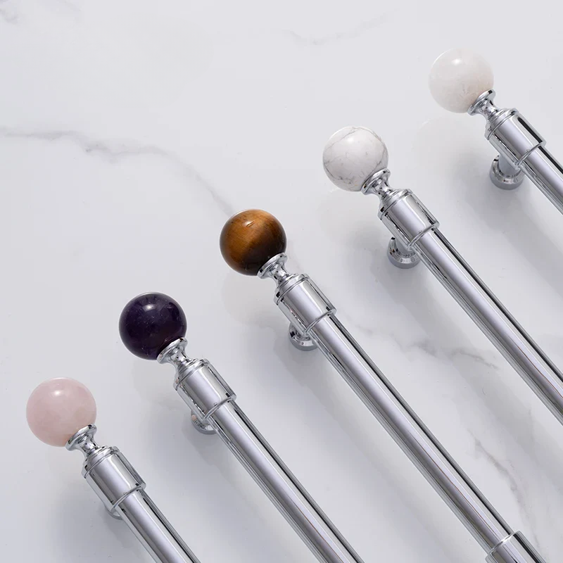 Set of silver telescopic sticks with multicolored spherical ends on a light gray background