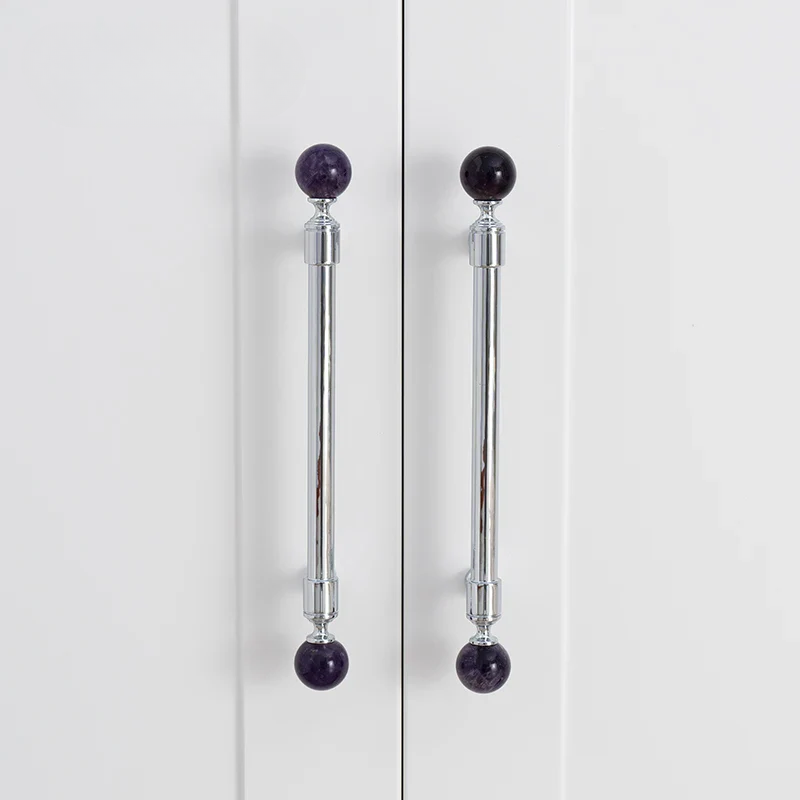 Cabinet doors with silver handles featuring purple spherical knobs on a white background