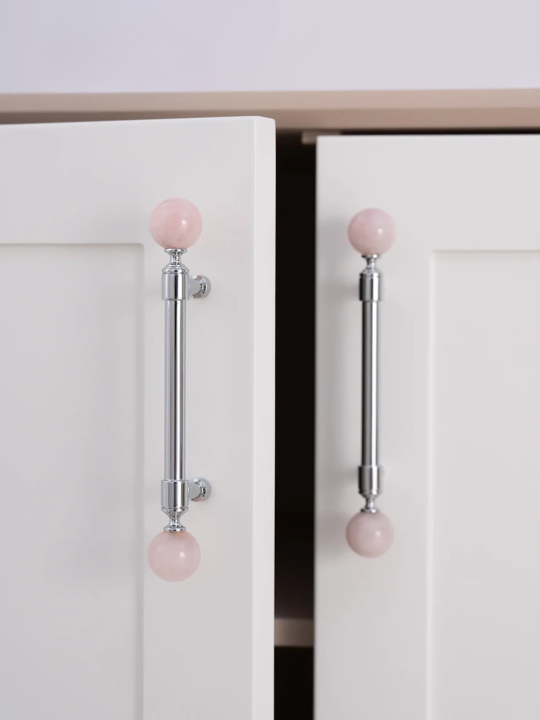White cabinet doors with pink knob pulls on a light background
