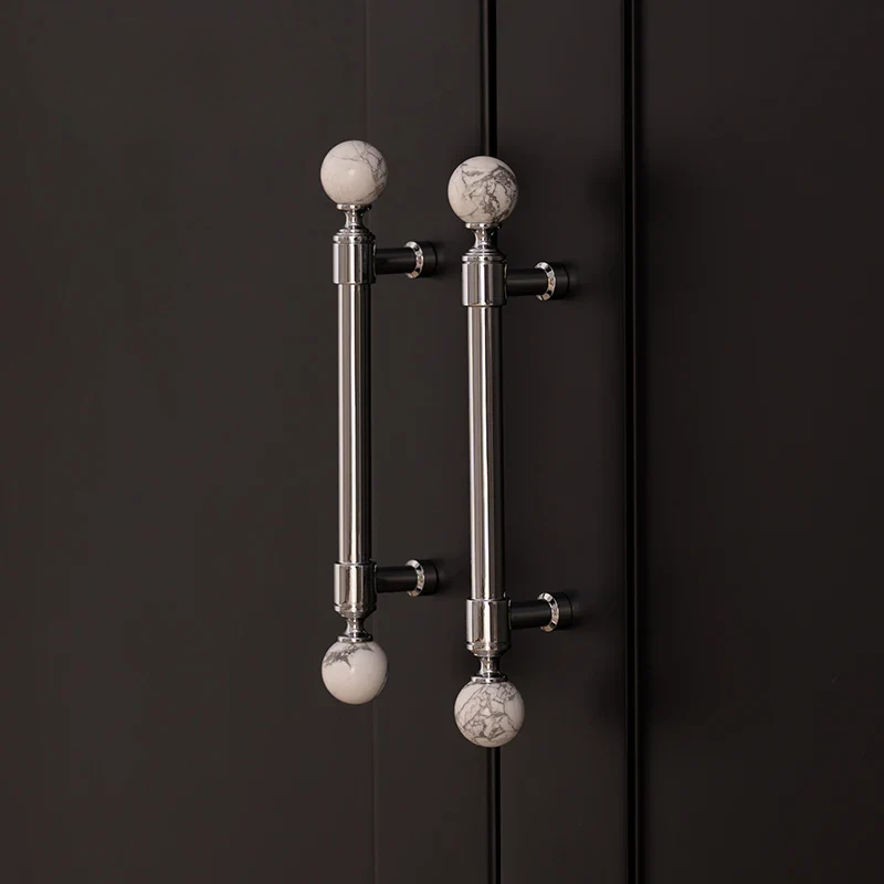Decorative cabinet handles with marble-like knobs on a black background