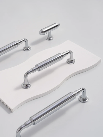 Set of chrome cabinet handles on a white surface