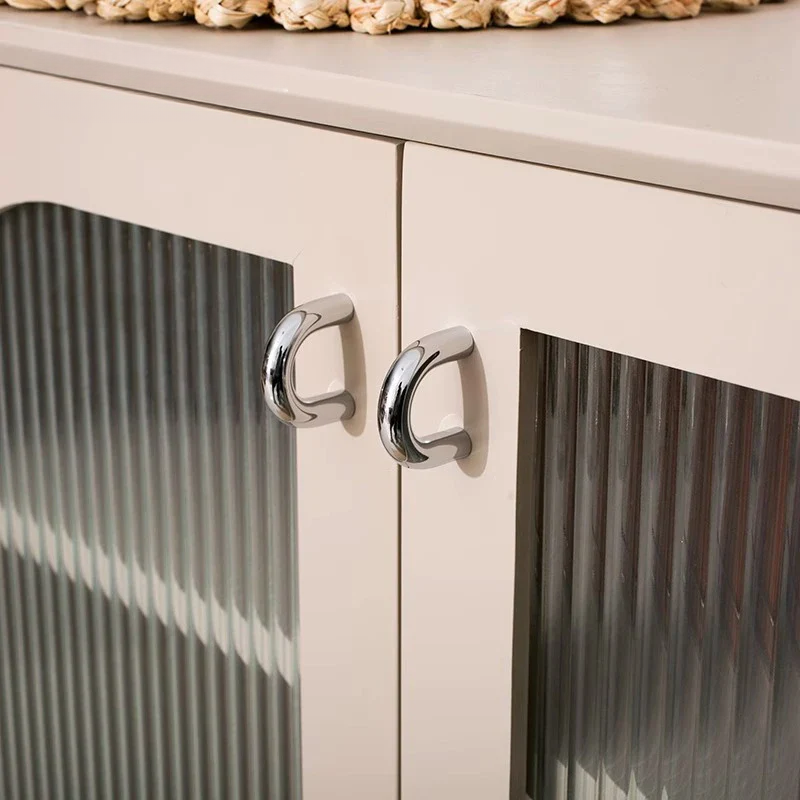 Close-up of a cabinet with metallic handles on a neutral background