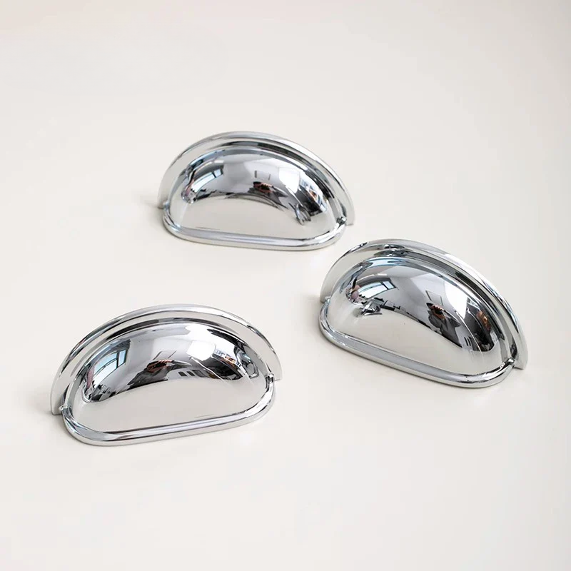 Three chrome car door handles on a white background