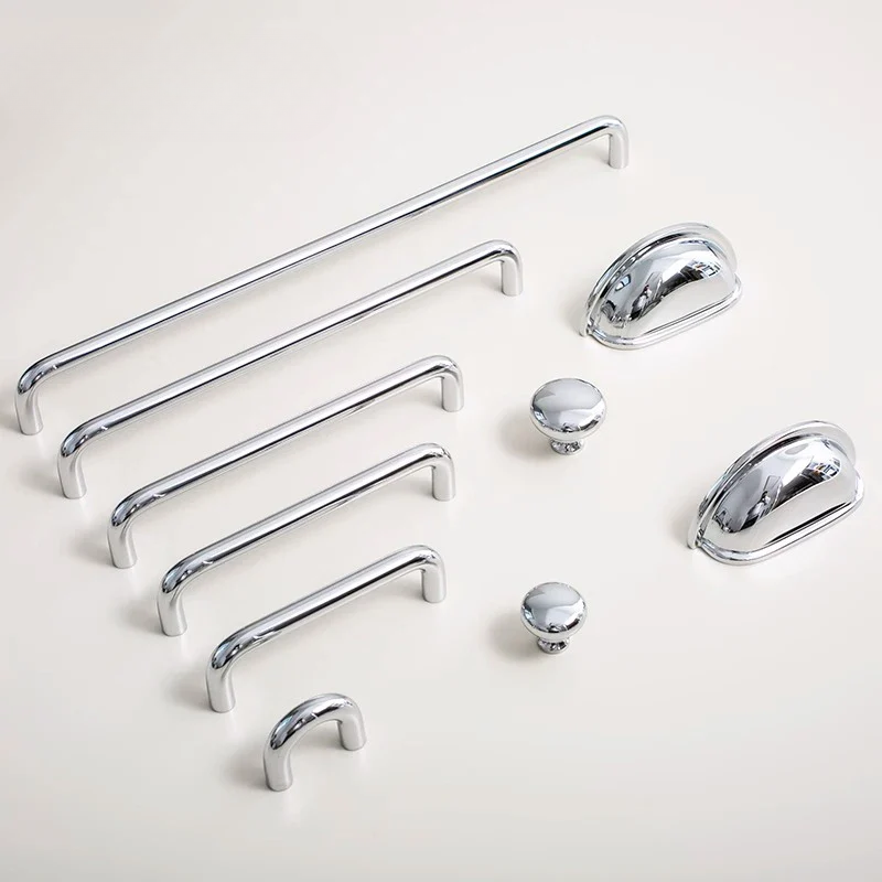 Set of chrome cabinet handles and knobs on a light background