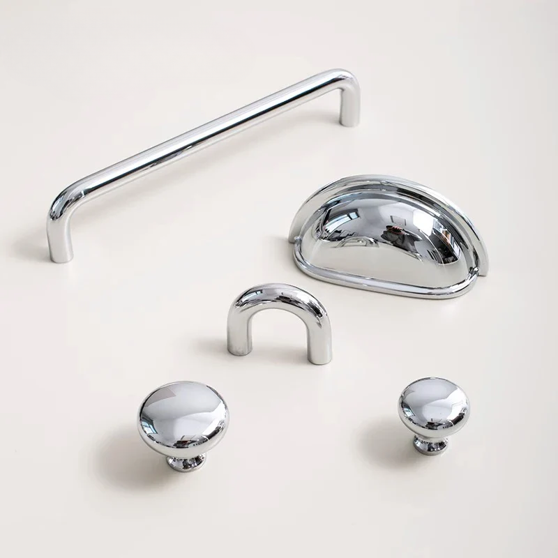 Collection of chrome cabinet handles on a light background