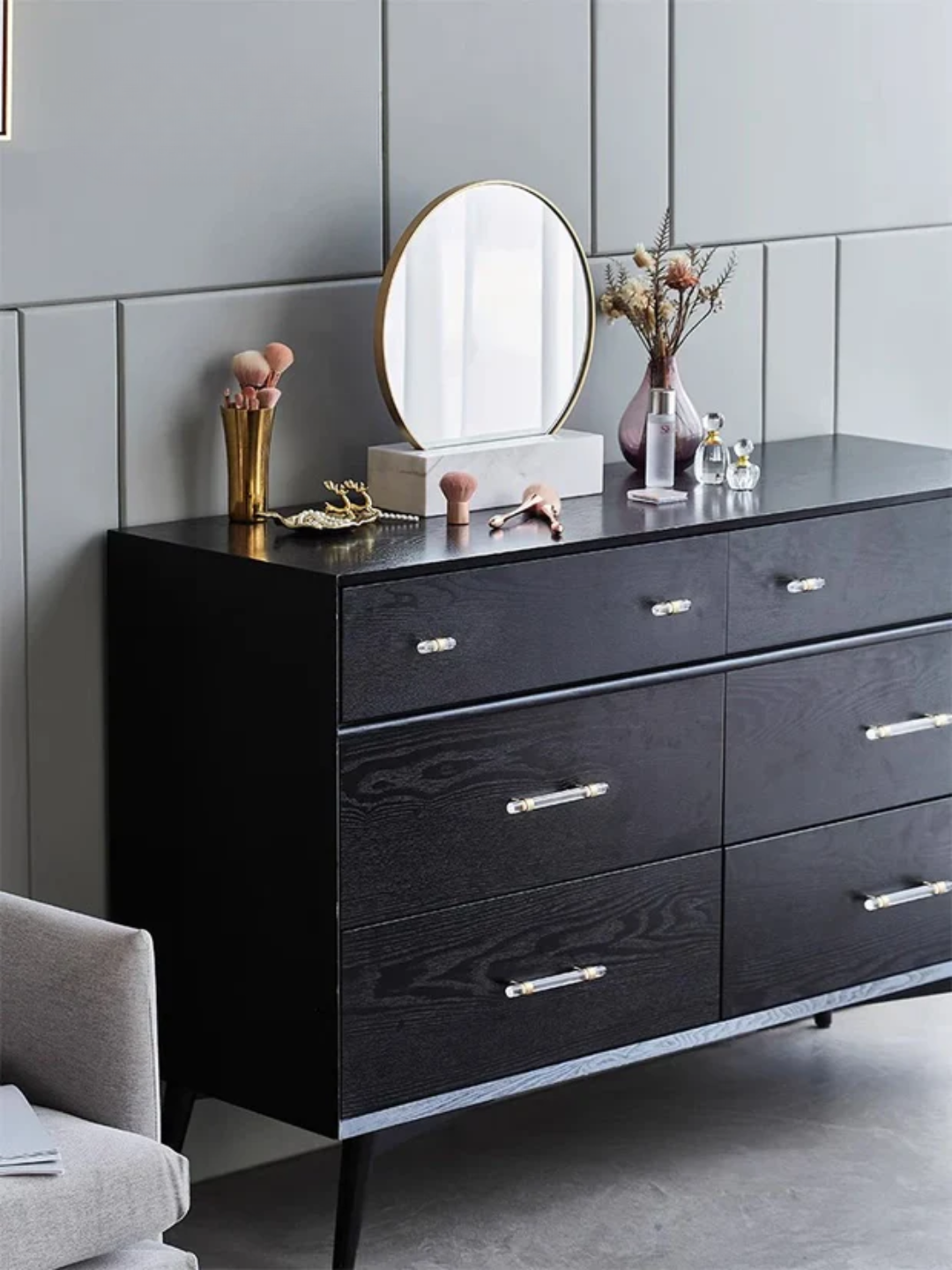 Black dresser with decorative items against a gray wall