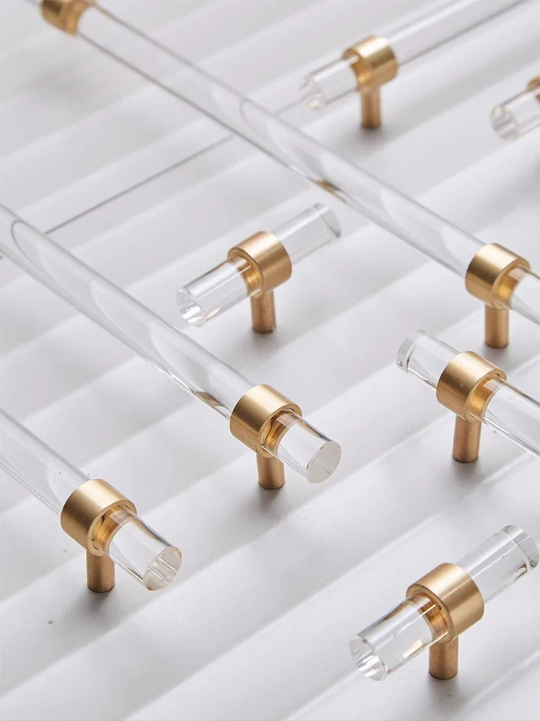 Clear acrylic handles with gold accents on a white background