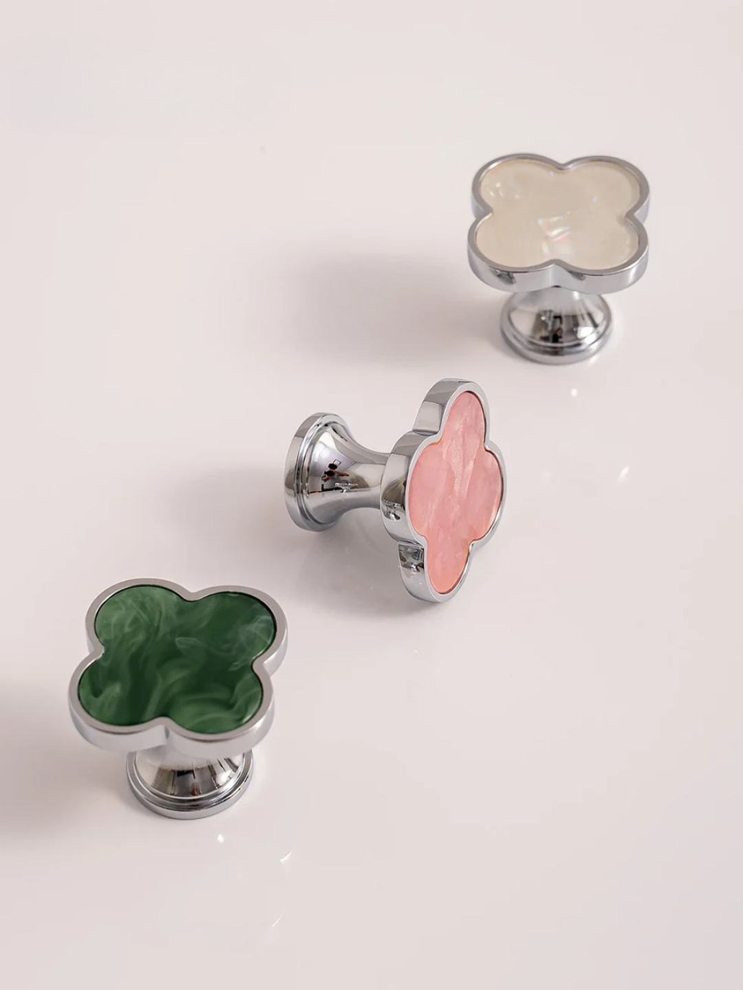 Three decorative cabinet knobs with floral designs on a white background