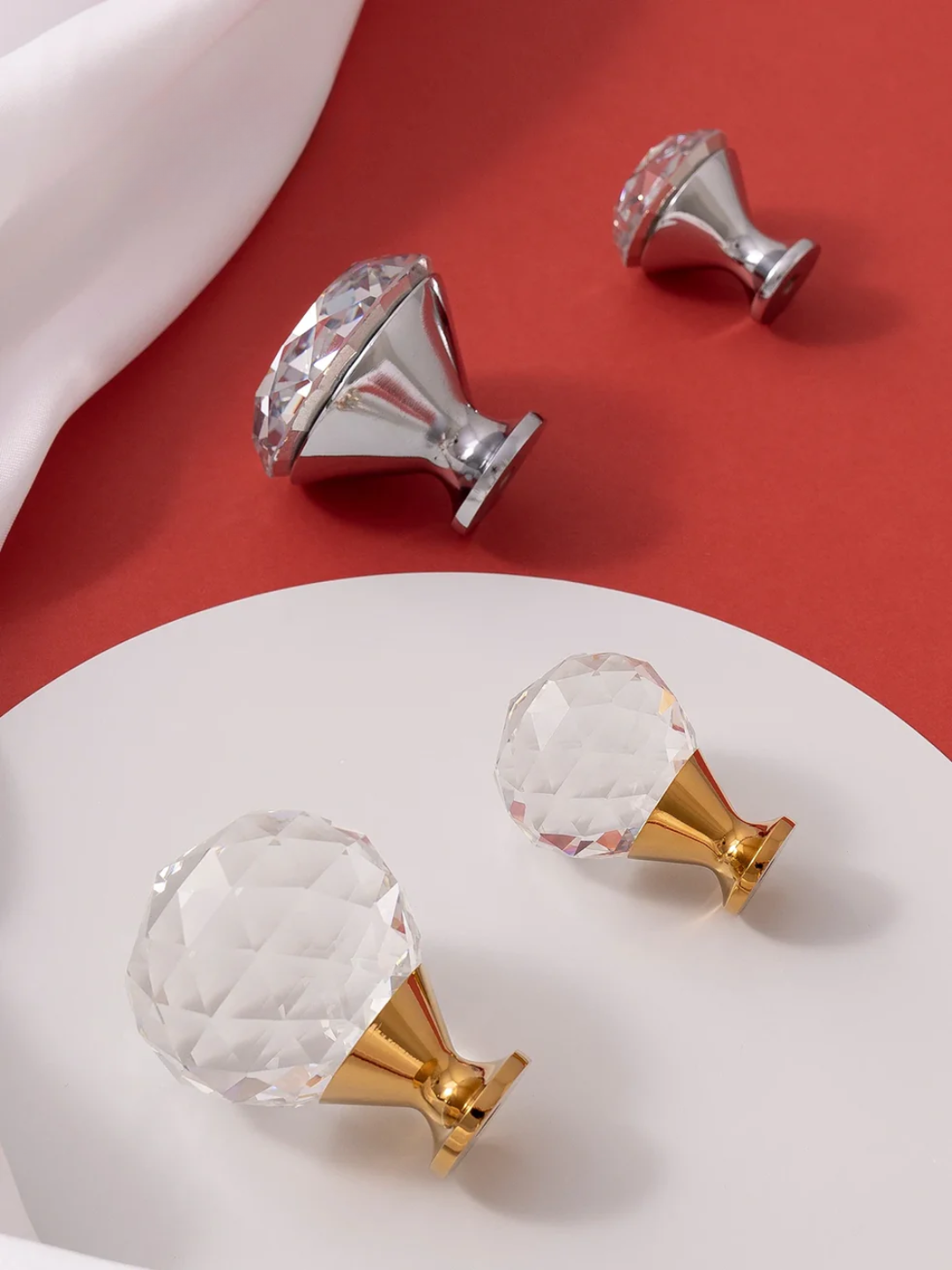 Crystal cabinet knobs in gold and silver on a red and white background