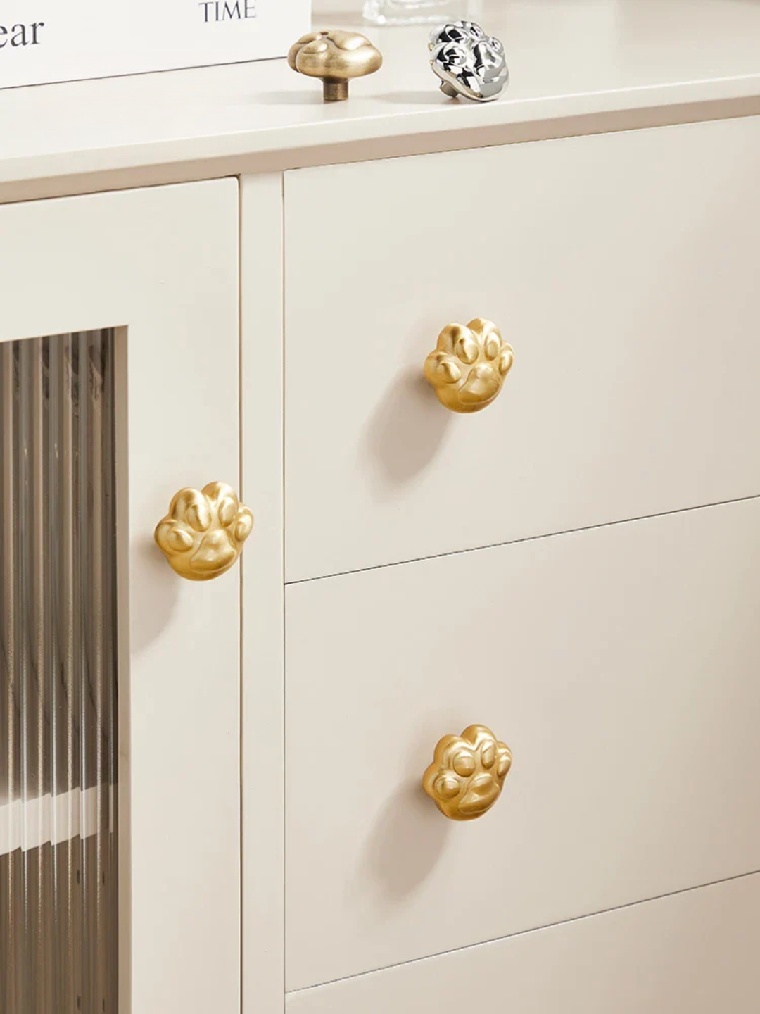 Close-up of a light-colored cabinet with gold handles