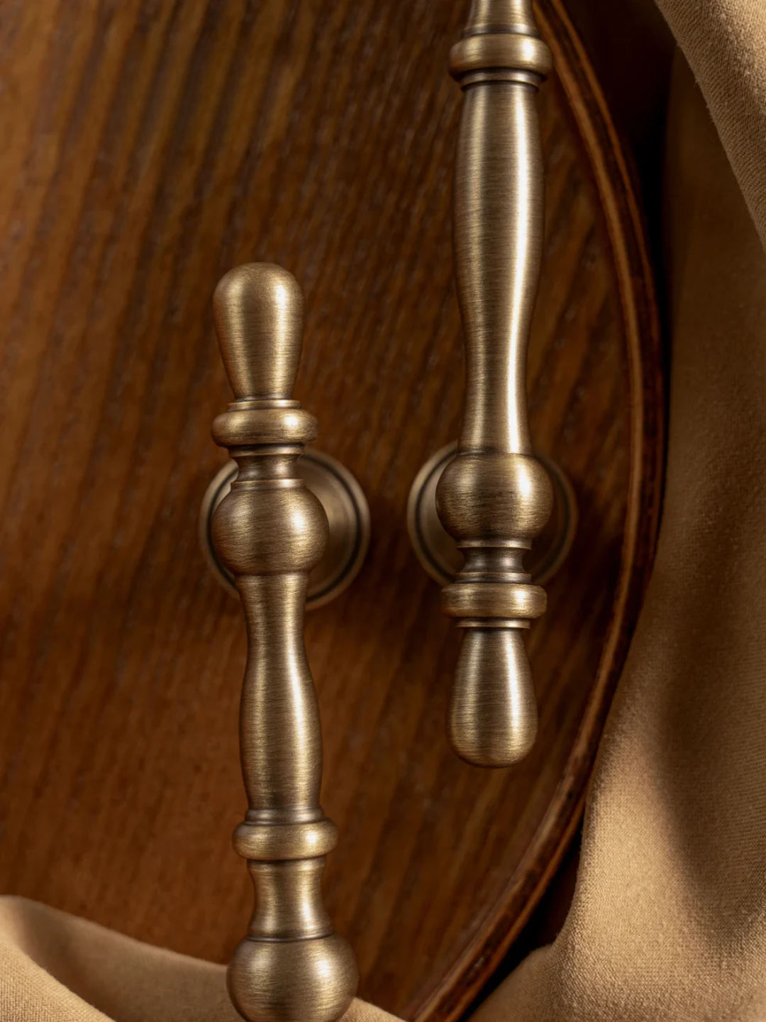 Close-up of two bronze handles on a wooden surface