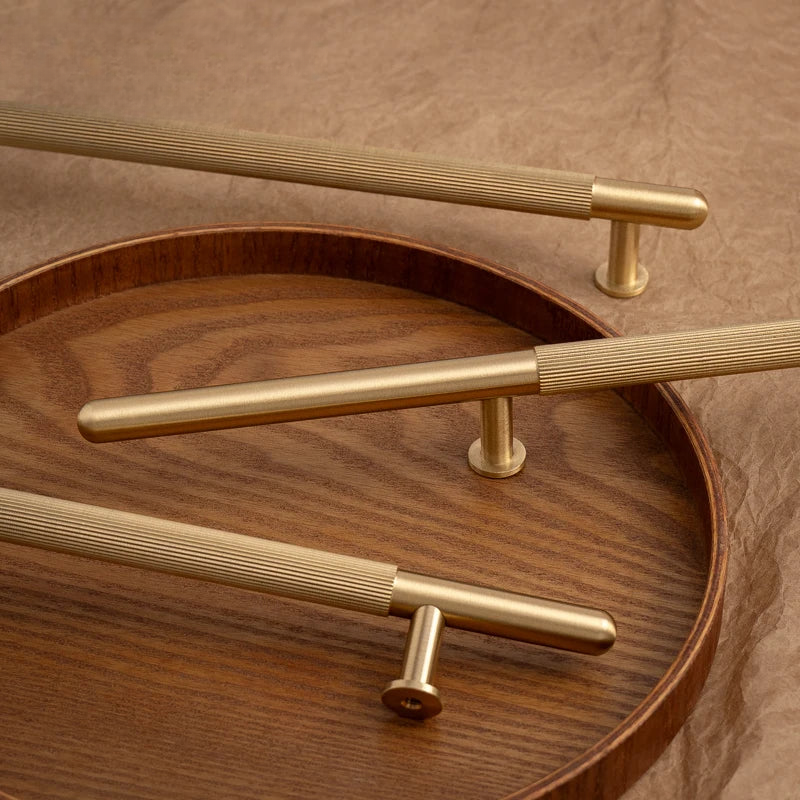 Gold handles on a wooden surface with a brown background