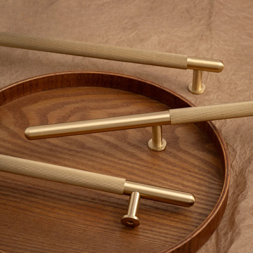 Gold handles on a wooden surface with a brown background