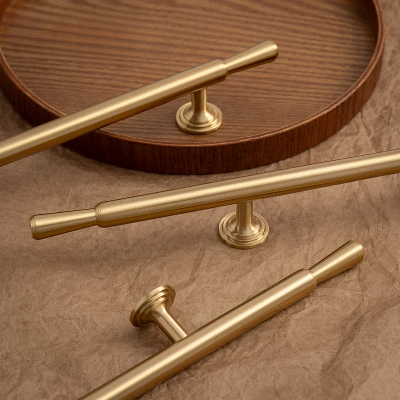 Gold cabinet handles on a wooden surface