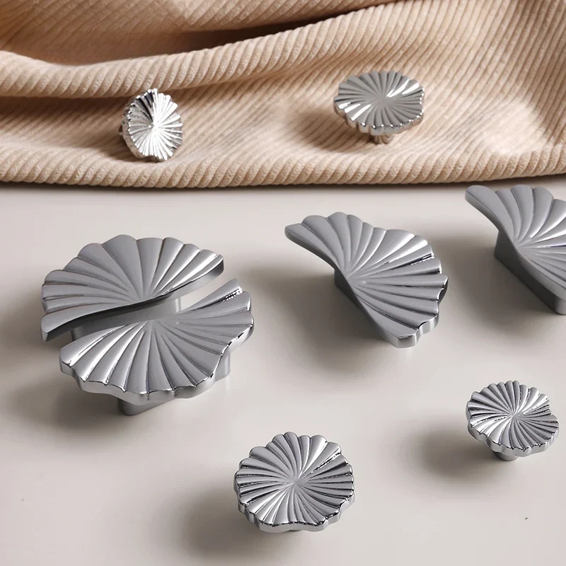 Silver shell-shaped objects on a beige fabric background
