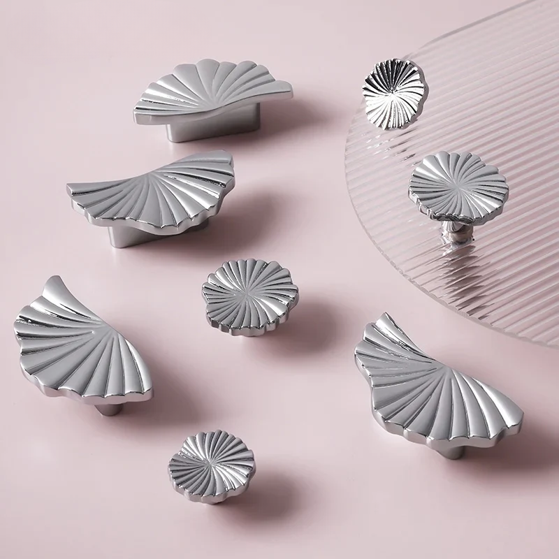 Silver shell-shaped objects on a pink background