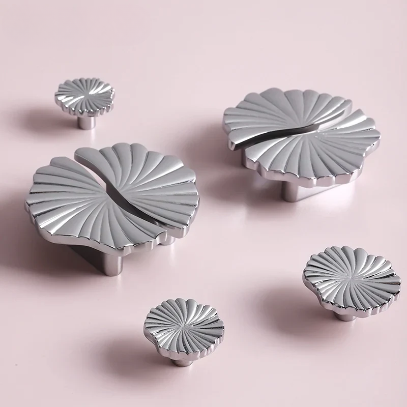 Set of silver decorative knobs on a pink background