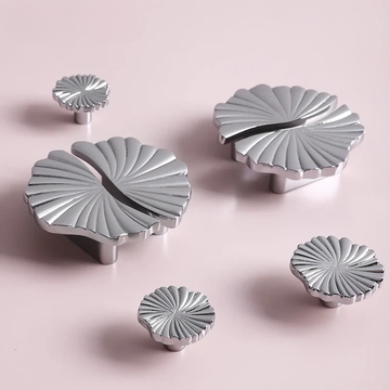 Set of silver decorative knobs on a pink background