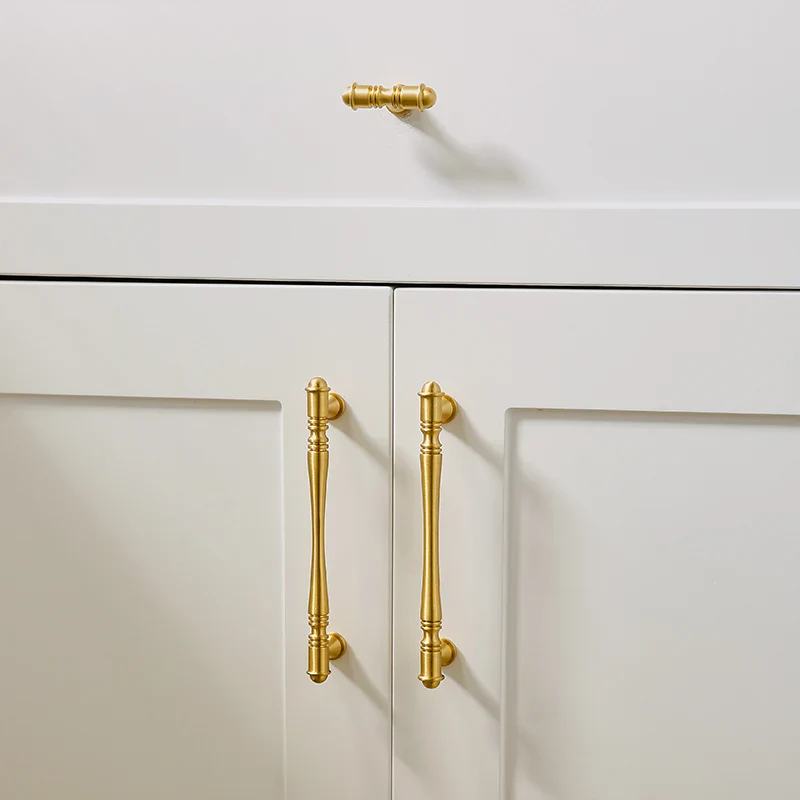 Close-up of white cabinets with gold handles on a white background