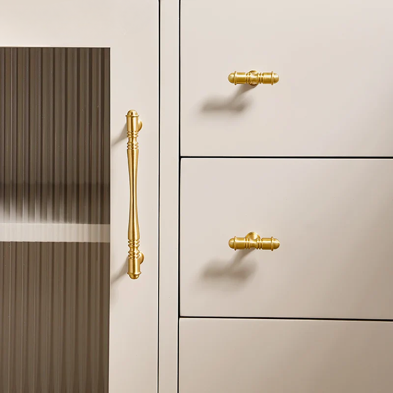 Beige cabinet with gold handles on a neutral background