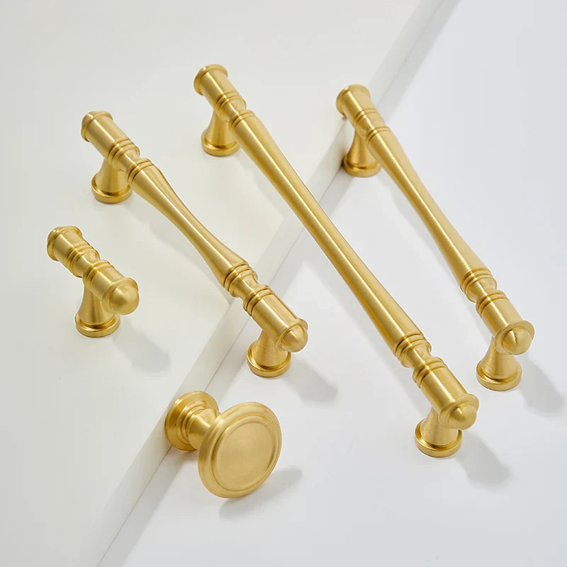 Set of gold cabinet handles on a white background