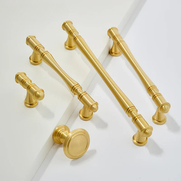 Set of gold cabinet handles on a white background