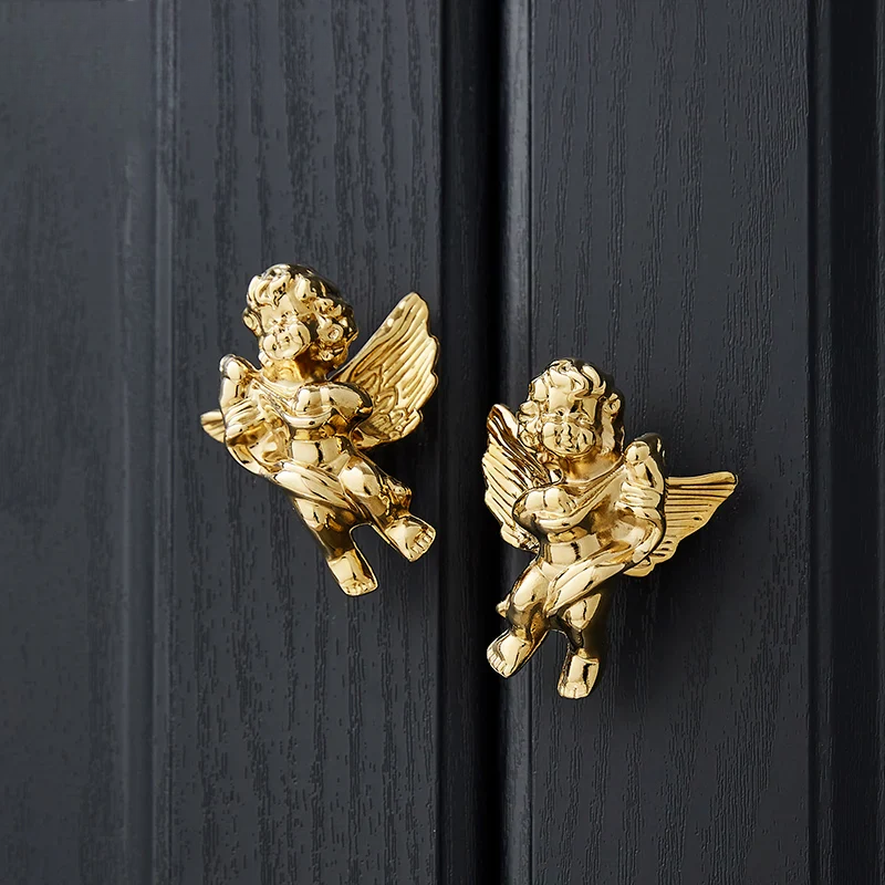 Gold angel door handles on a black wooden door