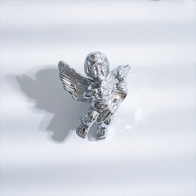 Silver angel figurine on a light gray background