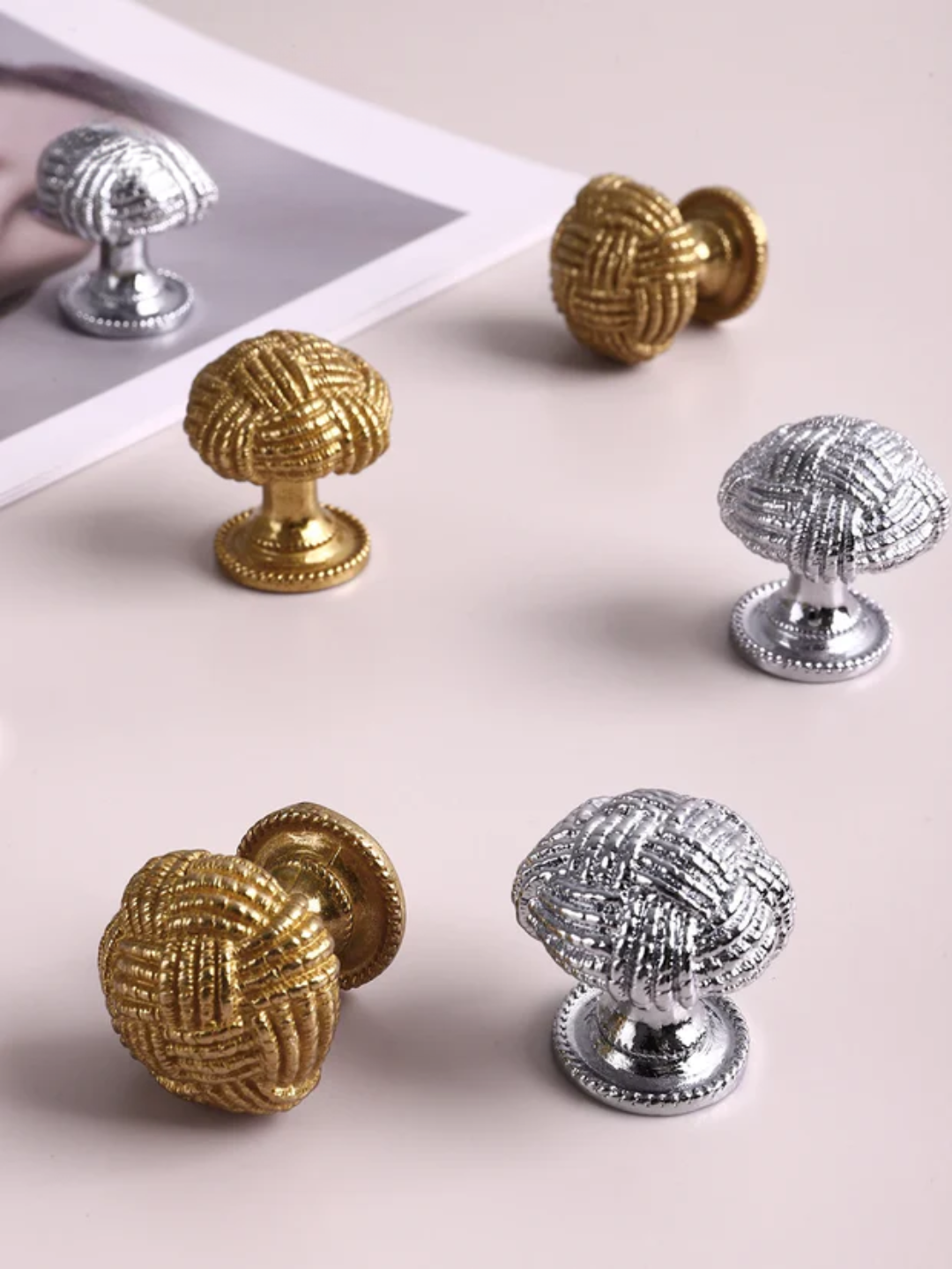 Set of gold and silver cabinet knobs on a light background