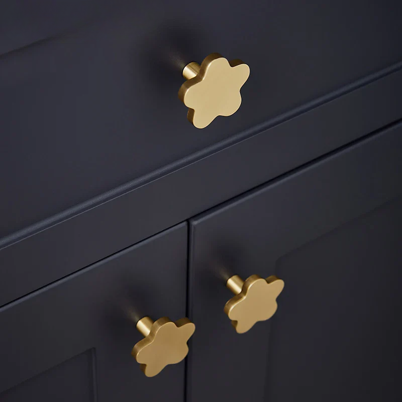 Close-up of a navy cabinet with gold star-shaped knobs