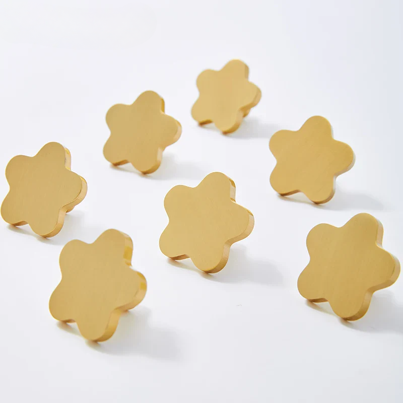 Gold flower-shaped coasters on a white background