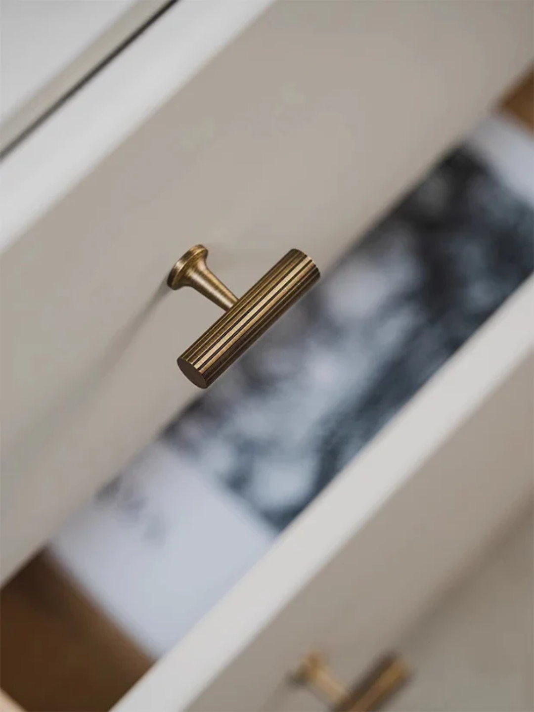 Gold cabinet handle on a white drawer with 'Santaya' branding.