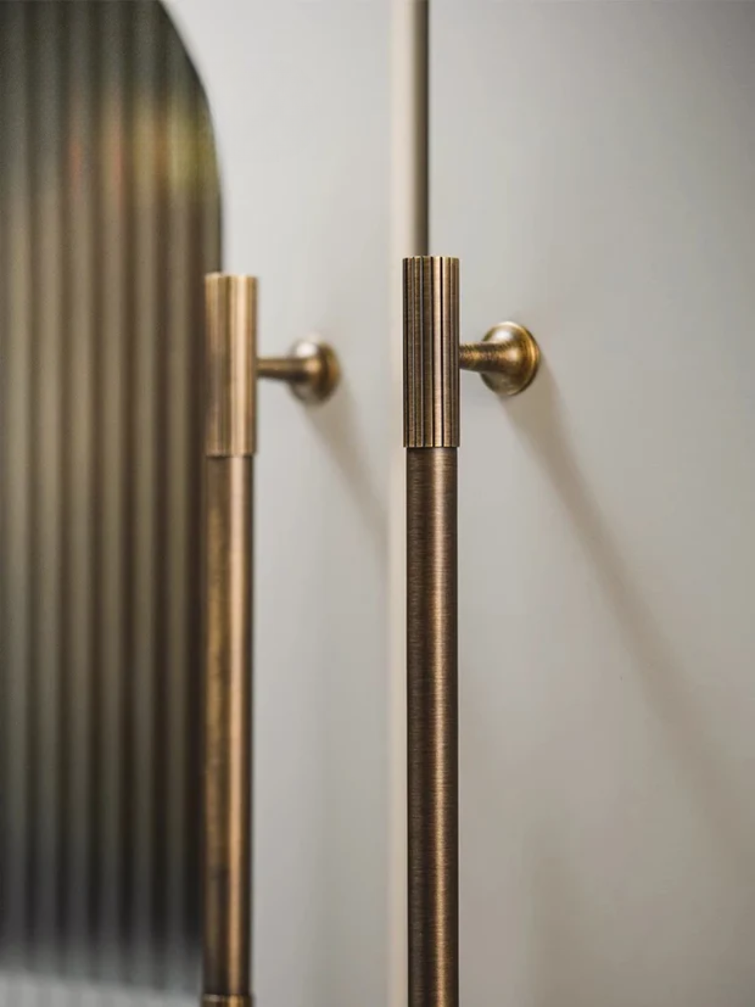 Close-up of a door with gold handles on a light background
