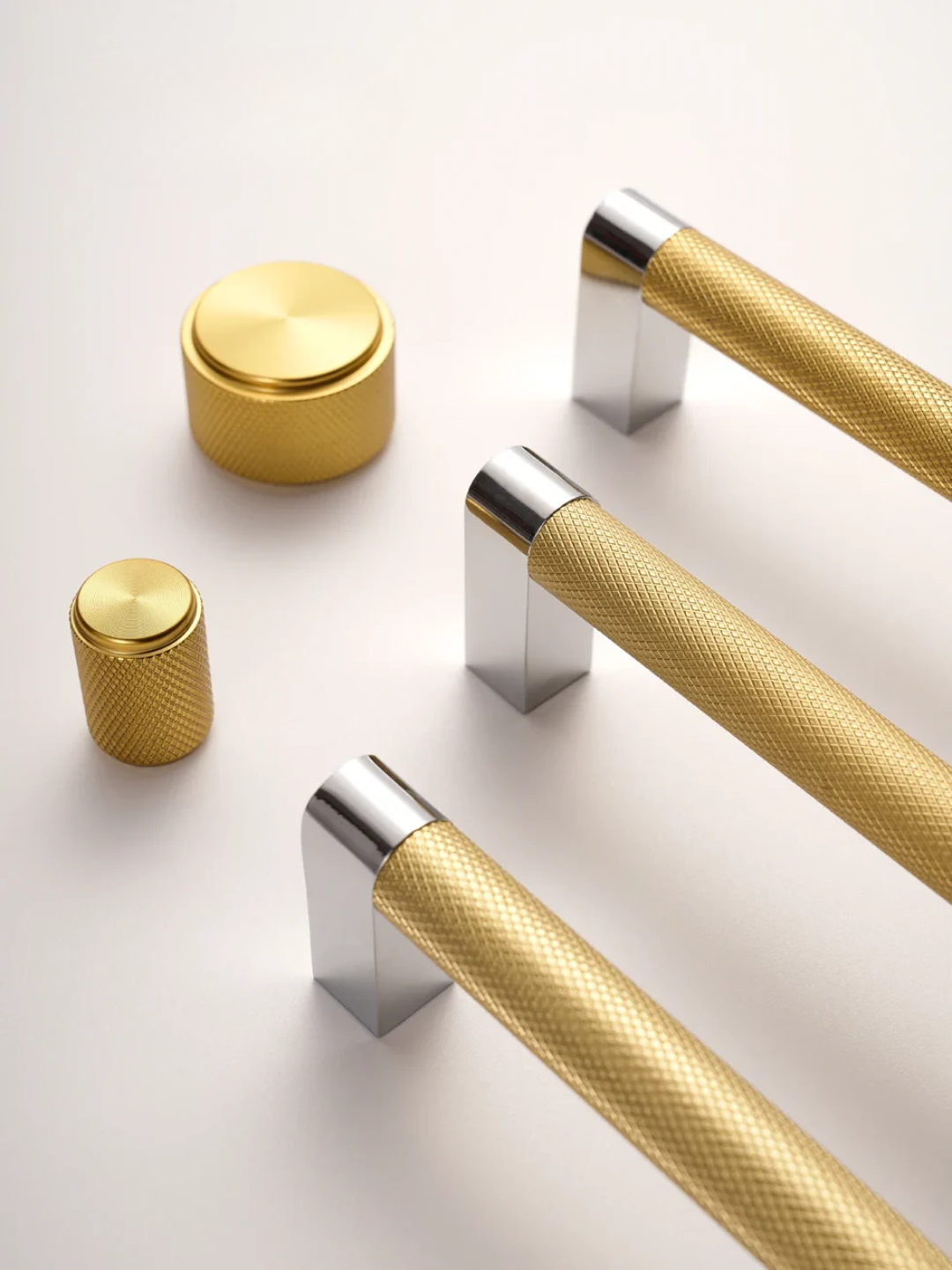 Gold and silver cabinet handles on a white background