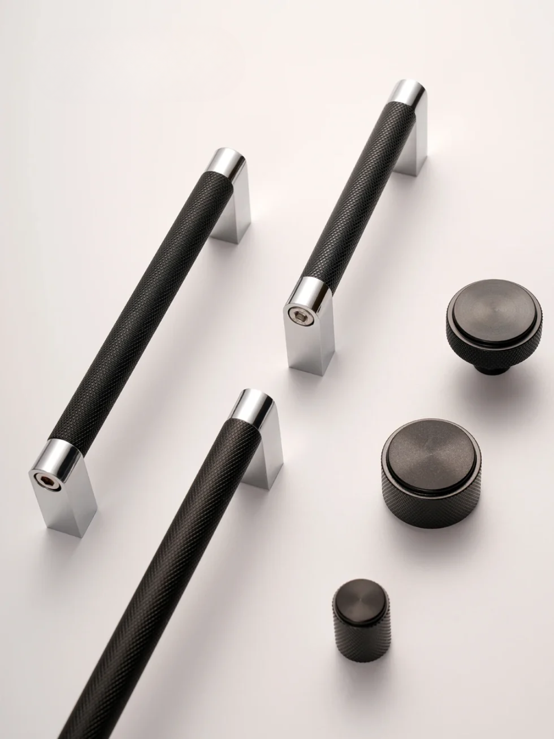 Set of black and silver door handles and knobs on a white background