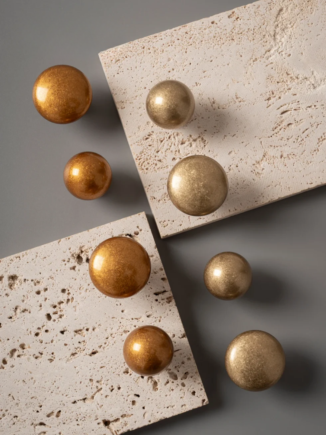 Gold spherical objects on textured stone surfaces with a neutral background