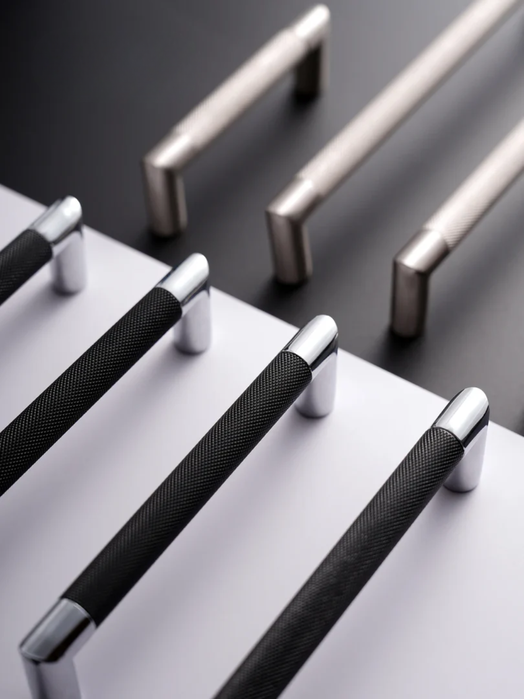 Set of metallic handles on a dark surface with a white background