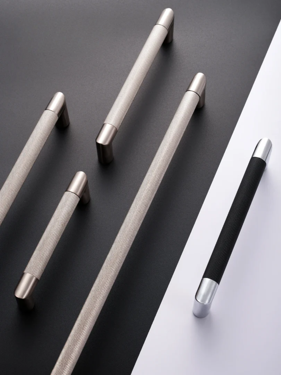 Set of metallic handles on a dark surface with a white background