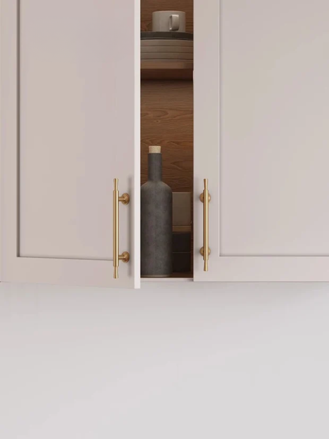 Open cabinet with gold handles displaying a dark bottle inside.