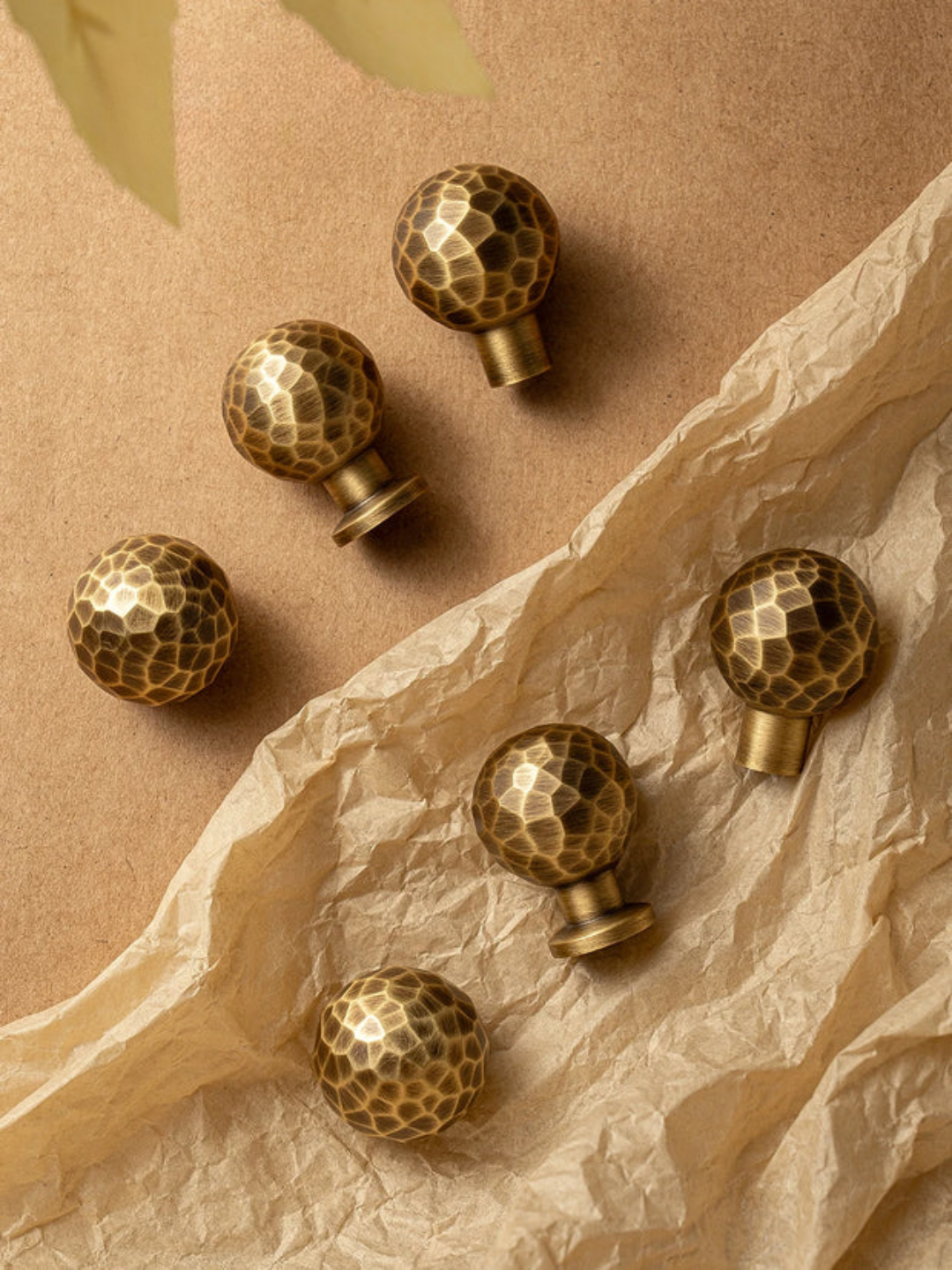 Gold spherical decorative items with honeycomb pattern on a beige surface