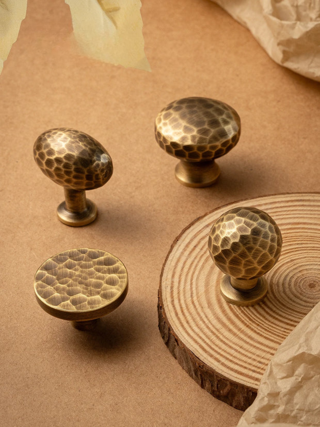 Brass cabinet knobs with a textured surface on a wooden surface, featuring the Santaya brand.