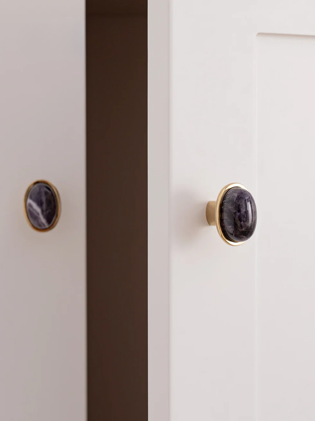 Close-up of a cabinet with black marble knobs on a white background